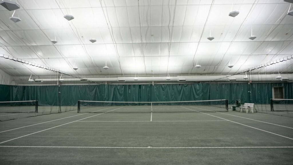Dimly lit indoor tennis court in training center